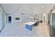 Open-concept living area boasts tile flooring, modern lighting, and a spacious kitchen with island at 6440 Maiden Sea Dr, Apollo Beach, FL 33572