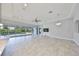 Spacious living room featuring a modern chandelier, tile flooring, and sliding glass doors overlooking the pool at 6440 Maiden Sea Dr, Apollo Beach, FL 33572