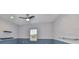 Well-lit home office with a modern ceiling fan and two dark shelves offering display space at 6440 Maiden Sea Dr, Apollo Beach, FL 33572