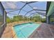 Screened in pool area with in-ground pool and hot tub, surrounded by brick patio and lush greenery at 6440 Maiden Sea Dr, Apollo Beach, FL 33572