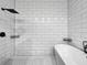 Modern tiled walk-in shower featuring subway tile, a shower head, and a bathtub at 6994 Fort King Rd, Zephyrhills, FL 33541