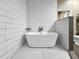 Modern bathroom featuring a freestanding tub, hexagon tile floor, and white subway tile walls at 6994 Fort King Rd, Zephyrhills, FL 33541