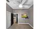 Nicely-sized carpeted bedroom with a ceiling fan, flat screen TV, two closets, and neutral walls at 6994 Fort King Rd, Zephyrhills, FL 33541