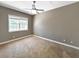 Bedroom with neutral walls, carpeted floor, a ceiling fan, and natural light streaming through the window at 6994 Fort King Rd, Zephyrhills, FL 33541