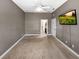 View of simple bedroom with mounted TV and door to attached bathroom at 6994 Fort King Rd, Zephyrhills, FL 33541