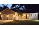 Charming single-story home featuring a two-car garage, landscaped yard, and a classic front entrance at dusk at 6994 Fort King Rd, Zephyrhills, FL 33541