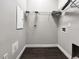 Clean utility room with wood-look tile floor, wire shelving, and washer and dryer hookups at 6994 Fort King Rd, Zephyrhills, FL 33541