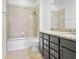 Bathroom featuring combination tub and shower, granite countertop and dark cabinets at 9309 Tradewater Oaks Ct, Riverview, FL 33578