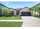 Charming single-story home featuring a two-car garage, well-maintained lawn and landscaped garden at 9309 Tradewater Oaks Ct, Riverview, FL 33578