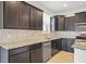 Modern kitchen featuring dark cabinets, stainless steel appliances, and granite countertops at 9309 Tradewater Oaks Ct, Riverview, FL 33578
