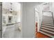 View of bathroom and staircase, showcasing white walls, patterned flooring, and vintage-style fixtures at 1001 S Oregon Ave, Tampa, FL 33606