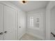 Hallway area with closet and window, featuring white walls, shuttered window, and decorative flooring at 1001 S Oregon Ave, Tampa, FL 33606