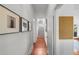 Hallway with hardwood floors, white walls, and decorative framed pictures. Stairs leading to the second floor at 1001 S Oregon Ave, Tampa, FL 33606