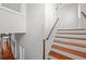 Staircase with a wooden handrail and steps, white risers, and a view down the hallway at 1001 S Oregon Ave, Tampa, FL 33606