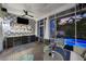 Inviting sunroom featuring a wet bar, comfortable seating, and views of the backyard pool at 1001 S Oregon Ave, Tampa, FL 33606