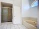 Bright bathroom featuring a soaking tub, large shower, and tiled floors at 1005 Cameo Crest Ln, Valrico, FL 33596