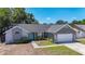 Exterior elevation showcasing the home's light blue front door, stone accents, and an attached garage at 1005 Cameo Crest Ln, Valrico, FL 33596