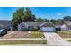 Charming single-story home featuring stone accents, attached two-car garage, well-manicured lawn, and bright turquoise front door at 1005 Cameo Crest Ln, Valrico, FL 33596