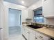 A kitchen with white cabinets, contrasting dark hardware, backsplash and sink with window view to the outside at 1005 Cameo Crest Ln, Valrico, FL 33596