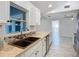 Bright kitchen featuring sleek marble tile flooring, white cabinets, contrasting backsplash and a view to the backyard at 1005 Cameo Crest Ln, Valrico, FL 33596