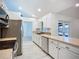 Bright kitchen offering stainless steel appliances, white cabinets, and a long stone countertops at 1005 Cameo Crest Ln, Valrico, FL 33596
