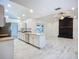 Open-concept living room and kitchen offering sleek marble tile, granite counter tops, and cozy stone fireplace at 1005 Cameo Crest Ln, Valrico, FL 33596