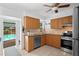 Well-equipped kitchen featuring wood cabinetry, tile backsplash, and stainless steel appliances at 10442 Cirimoya Ln, Seminole, FL 33772