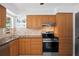 Functional kitchen showcasing wooden cabinets, modern appliances, and ample counter space at 10442 Cirimoya Ln, Seminole, FL 33772