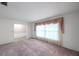 Bright living room with a view into the dining room, featuring pink carpeting and neutral walls at 111 W Anglewood Dr, Brandon, FL 33511