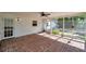 Inviting screened patio featuring a red brick floor, ceiling fan, and views of the backyard at 111 W Anglewood Dr, Brandon, FL 33511