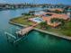 Aerial view of house with in-ground pool, boat dock, lush landscaping and canal waterfront views at 11625 5Th E St, Treasure Island, FL 33706