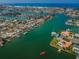 Wide aerial shot of waterfront community with canal access, boat docks, lush landscaping and residential homes at 11625 5Th E St, Treasure Island, FL 33706
