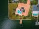 Bird's-eye view of house with swimming pool, wooden boat dock, lush lawn and canal waterfront access at 11625 5Th E St, Treasure Island, FL 33706