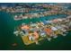Aerial view of waterfront community featuring canal access, docks, lush landscaping and houses with swimming pools at 11625 5Th E St, Treasure Island, FL 33706