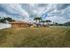 Expansive grassy backyard, single-story home, palm trees, white vinyl fence and canal waterfront view at 11625 5Th E St, Treasure Island, FL 33706