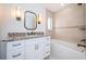 Bathroom with granite counters, neutral tiled walls, white cabinets and drawers and bathtub with shower at 11625 5Th E St, Treasure Island, FL 33706