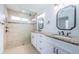 Elegant bathroom featuring double vanity, granite countertops, and walk-in shower at 11625 5Th E St, Treasure Island, FL 33706