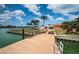 View from boat dock shows backyard, grass, waterfront views, lush tropical landscaping and single story home at 11625 5Th E St, Treasure Island, FL 33706