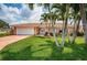 Charming home with a well-maintained lawn, beautiful palms, and a two-car garage at 11625 5Th E St, Treasure Island, FL 33706