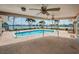 Covered outdoor patio overlooking inviting pool with tropical palm tree views and waterfront at 11625 5Th E St, Treasure Island, FL 33706