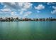 Scenic waterfront view of beautiful homes with boat docks under a clear blue sky with fluffy clouds at 11625 5Th E St, Treasure Island, FL 33706