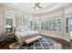 Sun-filled main bedroom featuring plantation shutters, tray ceiling, ceiling fan, and an ensuite bathroom at 13208 Malachite Dr, Bradenton, FL 34211