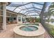A screened pool and hot tub features brick surround and lounge furniture at 13208 Malachite Dr, Bradenton, FL 34211