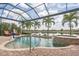 Gorgeous screened pool with brick surround, water feature, and lake view at 13208 Malachite Dr, Bradenton, FL 34211