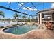 Outdoor pool with spa and covered outdoor kitchen overlooking the lake; perfect for entertaining at 13208 Malachite Dr, Bradenton, FL 34211