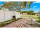 Relaxing backyard with a brick patio, grill, hammock, and a white picket fence offering privacy at 13696 Orange Sunset Dr # 13696, Tampa, FL 33618