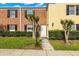 A view of the home's exterior with a brick facade, dark shutters, and small trees enhancing the front yard at 13696 Orange Sunset Dr # 13696, Tampa, FL 33618