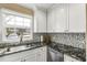 The kitchen features sleek stainless steel appliances, granite countertops, and a decorative mosaic backsplash at 13696 Orange Sunset Dr # 13696, Tampa, FL 33618