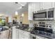 Open-concept kitchen with stainless steel appliances, granite countertops, and bar seating at 13696 Orange Sunset Dr # 13696, Tampa, FL 33618