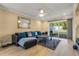 Inviting living room with wood flooring, a ceiling fan, and sliding glass doors leading to an outdoor space at 13696 Orange Sunset Dr, Tampa, FL 33618
